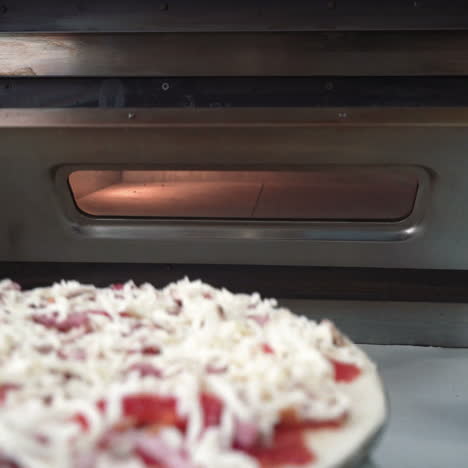 chef puts a raw pizza into the oven. making pizza. cooking food. sqare video