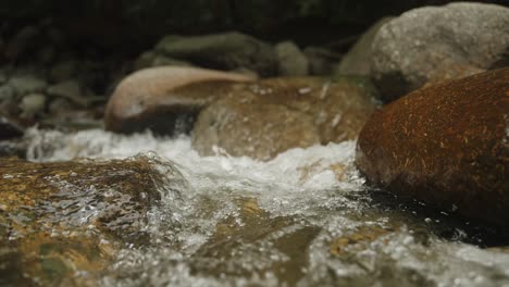 poca profundidad de campo estante de enfoque gran angular de agua de río rocas que fluyen