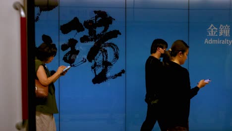 commuters pass by in hong kong subway station