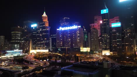 aerial shot of panasonic building situated at downtown of hong kong surrounded by tall buildings. night view.