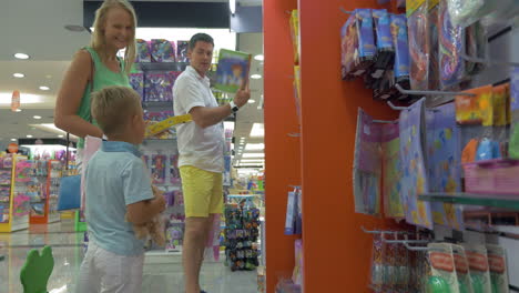 mother father and son in toy shop