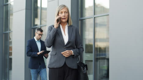 Mujer-De-Negocios-Madura-Hablando-Por-Teléfono-En-La-Calle