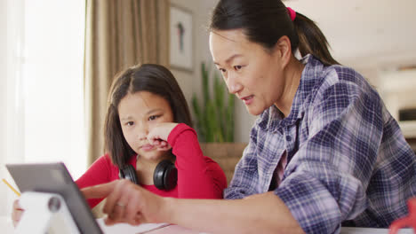 video of happy asian mother and daughter doing homework together