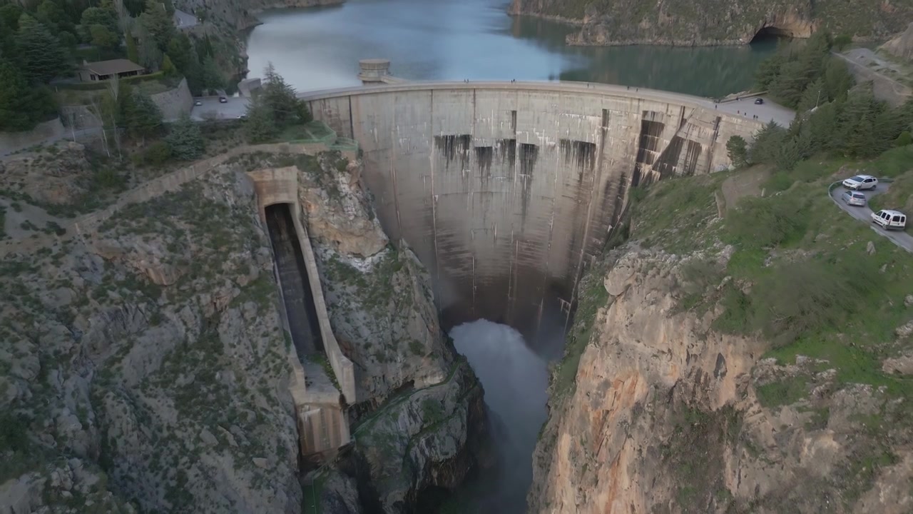 Vandreservoir og dæmning mellem bjerge. Buedæmning inde i en bjergkløft. Luftfoto. Quentar-dæmningen. Spanien