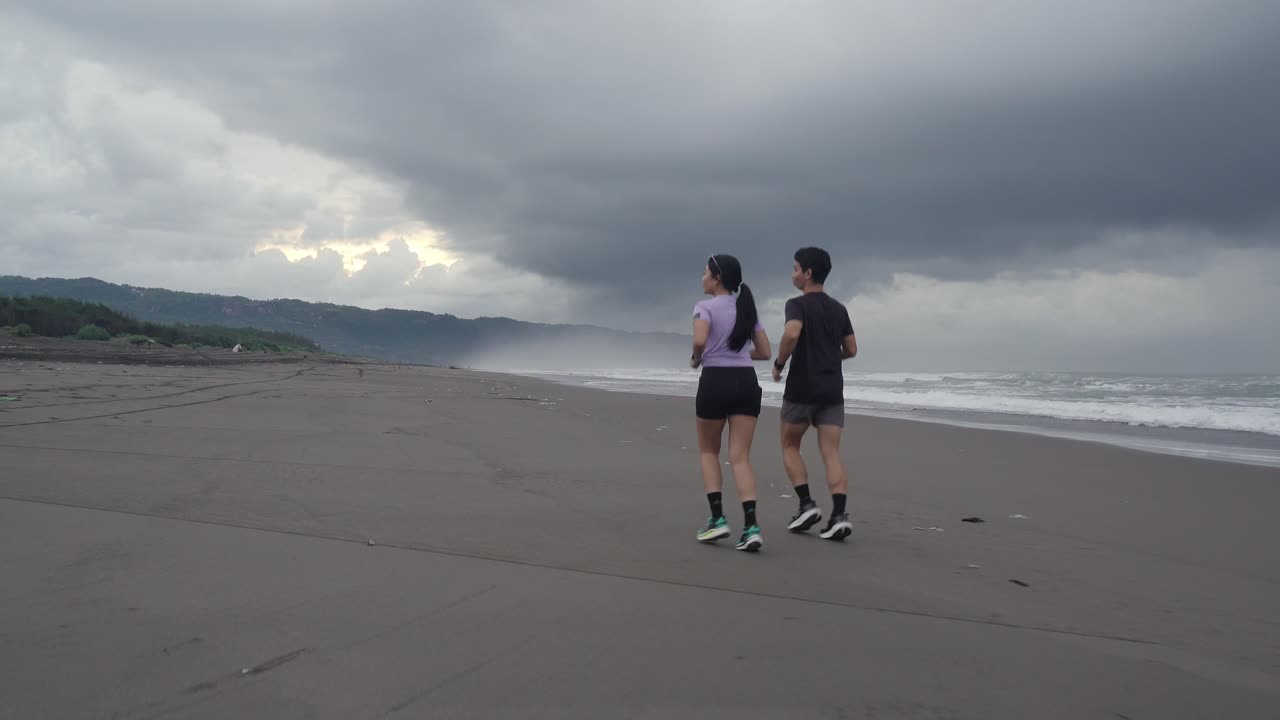 Couple Running on a Beach at Sunset