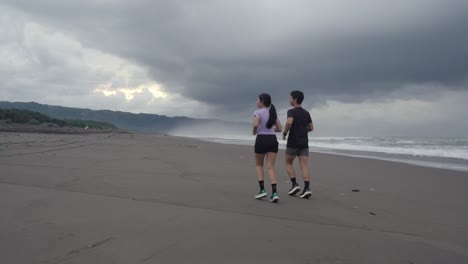 couple running on a beach at sunset