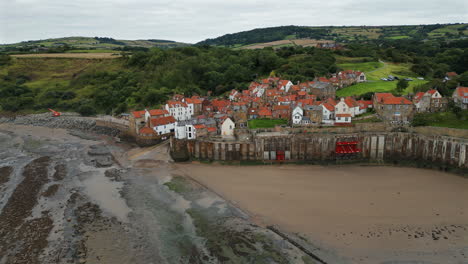 establishing aerial drone shot towards robin hood's bay at low tide