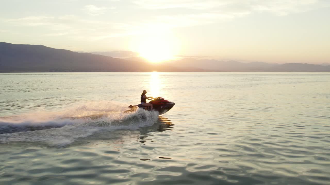 Kobieta na skuterze wodnym Sea Doo o zachodzie słońca na jeziorze Utah – ujęcie z lotu ptaka w zwolnionym tempie
