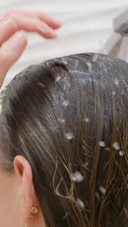 woman washing her hair with shower, water. close up.back view of beautiful naked young woman taking shower in bathroom. beauty spa concept.