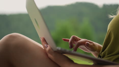 mujer escribe un post para la página del blog en una computadora portátil en el eco resort