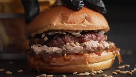 Chef-hand-pressing-juicy-burger-dripping-sauce-in-slow-motion