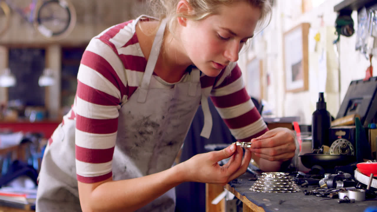 женщина, ремонтирующая части велосипеда в мастерской 4k