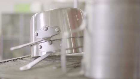 shiny stainless pots in the restaurant kitchen - selective focus