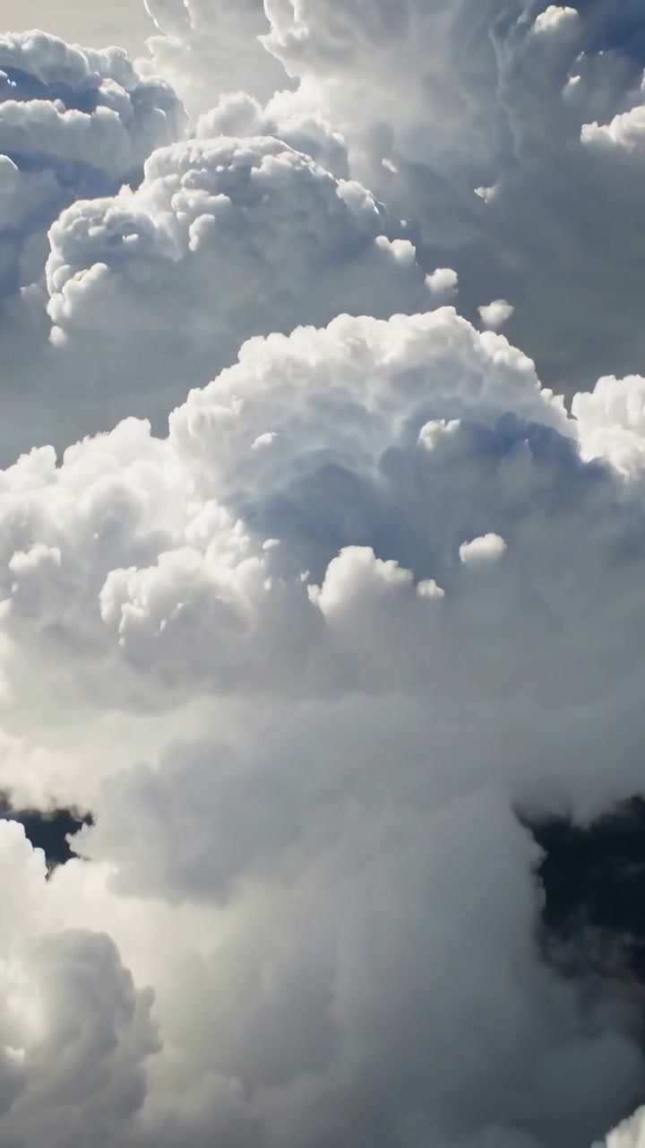 Video vertikal: Kamera turun di atas puncak awan, menampakkan menara awan dan pusat bayangan terkait cuaca.
