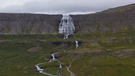 stunning landscape of dynjandi waterfall cascading down the icelandic mountain and river in the westfjords, iceland