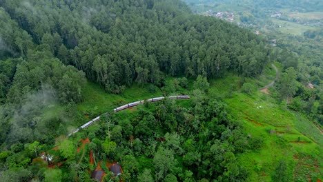 breathtaking aerial drone footage of a train crossing the iconic nine arches bridge in ella, sri lanka.