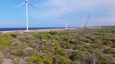Aerial shot of windmills along the rocky coastline of an island, showcasing renewable energy and natural beauty