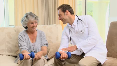 doctor showing to his patient the use of dumbbells