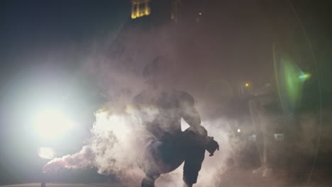 african american man kneeling in smoke and headlights