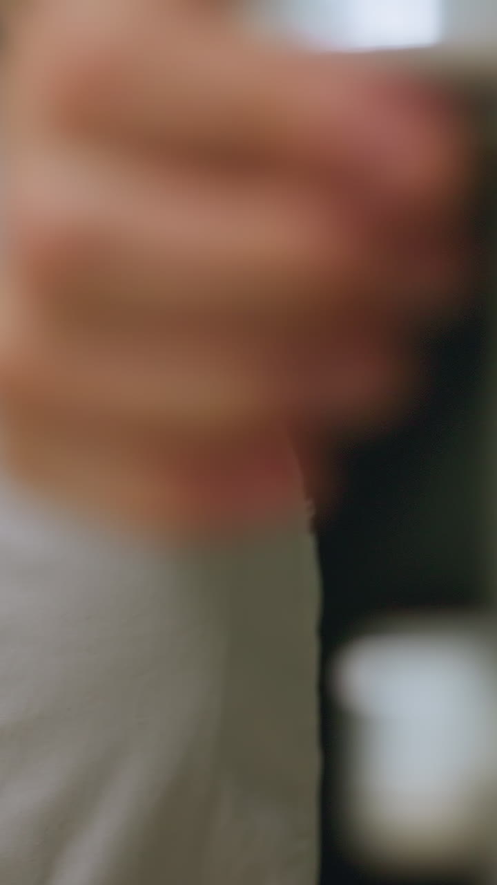 Personal caucásico acciona el brazo junto a la cerradura de ojo de cerradura que bloquea un armario de madera. Primer plano del cierre metálico y la textura de la veta. Suave giro de la llave. Silencioso protocolo de seguridad de fin de turno en el pasillo de la clínica. Protección