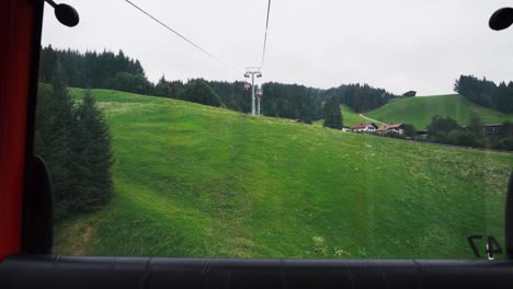 view from a cable car ascending a green mountain