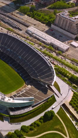 stadium soldier field in chicago. aerial view on the structure in the green park at the backdrop of speed road. vertical video