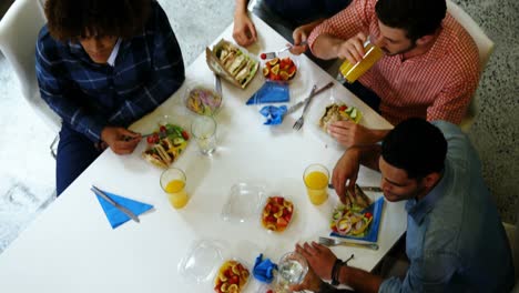 ejecutivos felices interactuando mientras desayunan