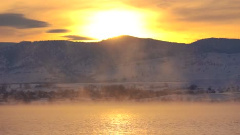 Flock-of-Canada-geese-flying-low-over-a-misty-lake-against-a-background-of-mountains