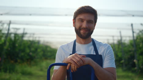 cheerful entrepreneur looking camera at agriculture plantation in summer.