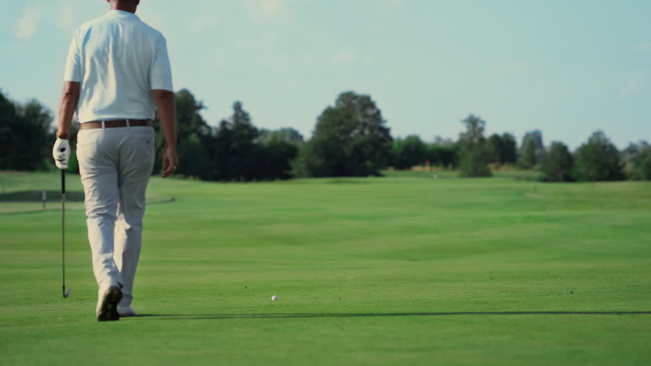 Atleta professionista che gioca a golf all'aperto. Uomo che cammina su un campo da golf in estate.