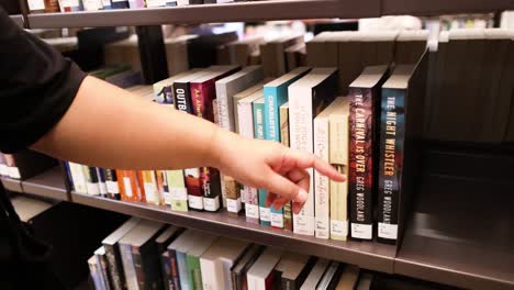 hand choosing a book in library