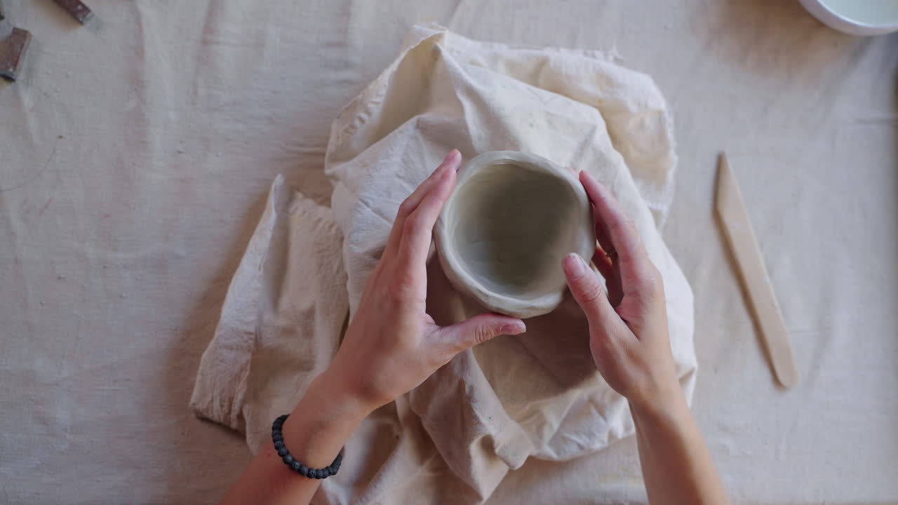 mujer formando un cuenco de arcilla