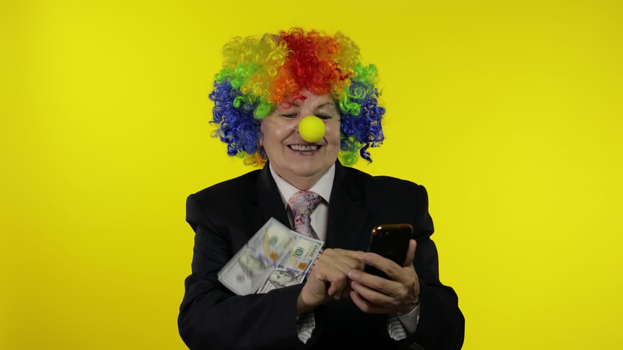 Clown businesswoman freelancer receives money income while using smartphone