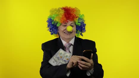 clown businesswoman freelancer receives money income while using smartphone