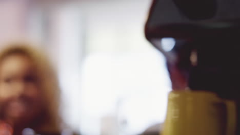 barista preparando una bebida de café para diversas personas en la cola de la cafetería