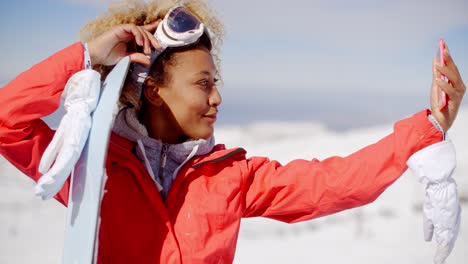 Young-woman-taking-her-selfie-with-a-snowboard