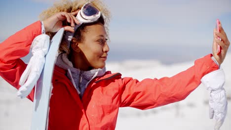 young woman taking her selfie with a snowboard