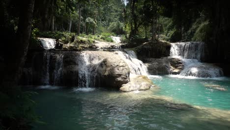 cámara lenta panorámica de la cascada de kuang si con un hermoso agua azul verde