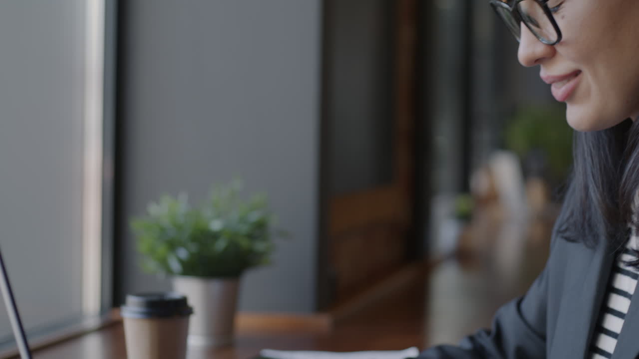 mujer trabajando en una computadora portátil en una cafetería