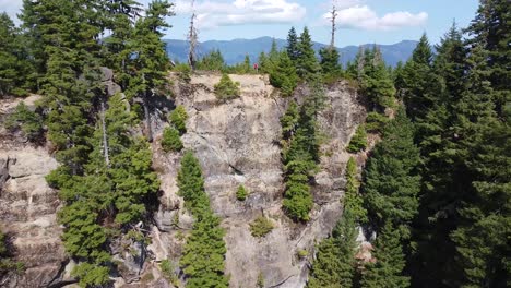 hiker standing on cliff summit of thunder mountain, vancouver island, bc, canada