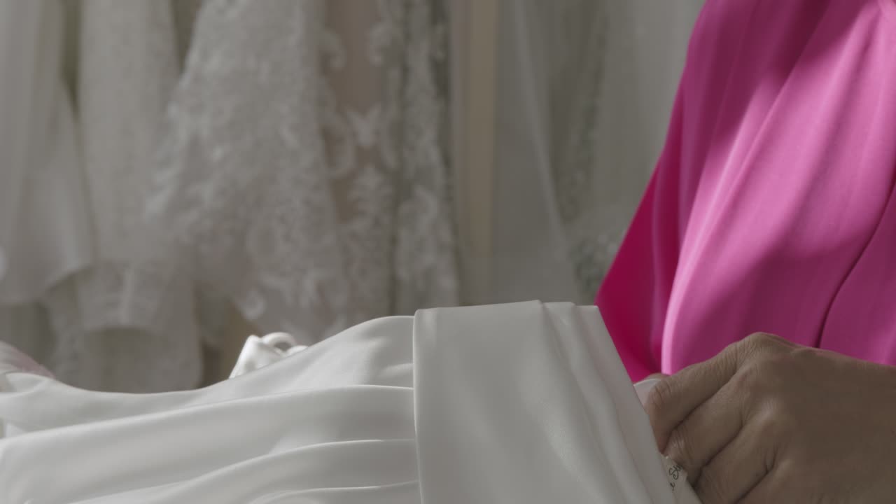 Intricate bridal gowns on display in soft lighting create an enchanting, romantic atmosphere. Close-up shot highlights delicate lace details, offering a dreamy bridal store ambiance