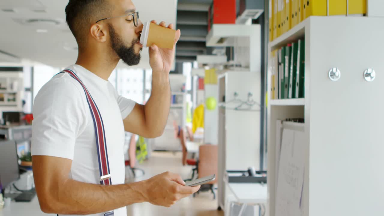 Architetto che usa il cellulare mentre beve un caffè 4k