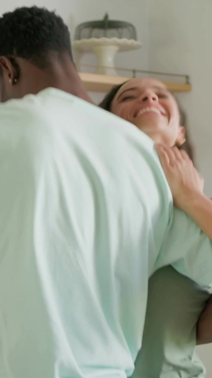 Vertical video: Turning woman reaching partner's hand in kitchen, couple dancing by frying pan