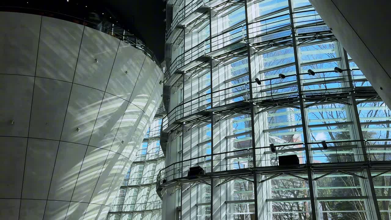 Modern glass architecture with curved walls at The National Art Center, Tokyo
