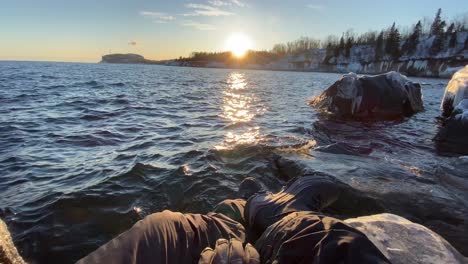 Ein-Mann-Aus-Der-Ego-Perspektive-Blickt-Im-Winter-Auf-Den-Sonnenuntergang-Am-Ufer-Des-Lake-Superior-In-Minnesota