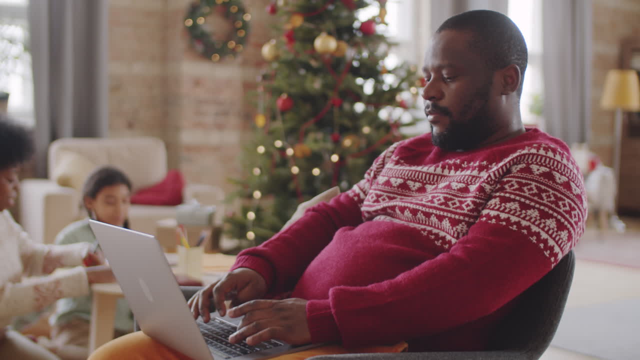African American Man Using Laptop on Christmas Day at Home