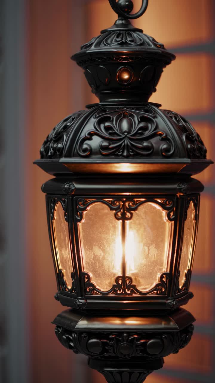 Video ravvicinato di una lanterna vintage decorata con design intricati, che si illumina delicatamente