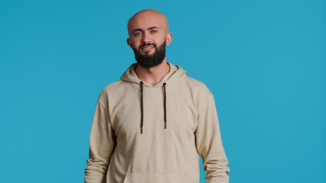 Arab male model doing no symbol on blue backdrop
