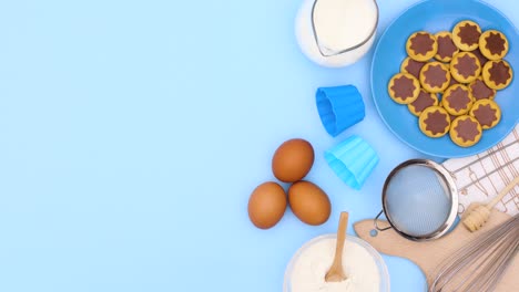 las galletas en placa azul y los ingredientes para hacer galletas aparecen en el lado derecho del tema azul.