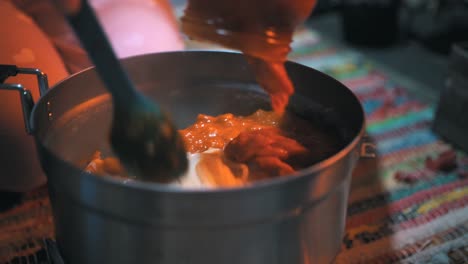 cooking pasta with a portable gas stove in a cottage in the nature, outdoor, camping